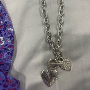 Silver Guess necklace with ringtones in one side and ? In Red in the other side